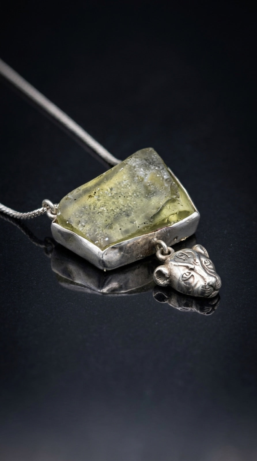 The Sekhmet Talisman — pale green desert glass in a hand-raised silver bezel
