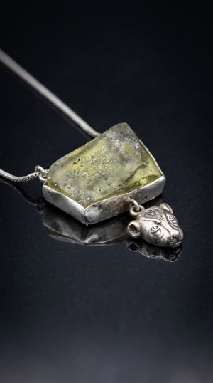 Three-quarter view of the Sekhmet Talisman showing the raw desert glass and silver bezel